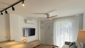 Um apartamento moderno com cozinha, sala de estar e varanda.