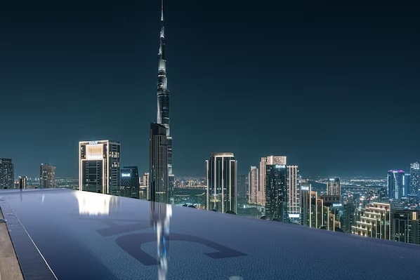 A rooftop pool with a city skyline in the background, including the Burj Khalifa.