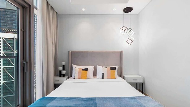 A modern hotel room with a large bed, a nightstand, a bedside table, and a window with curtains. - Ultra Luxurious! Stunning Views, 64th Floor Pool (Business Bay)
