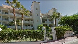 A multi-story hotel with balconies, palm trees, and a gated entrance. - Rancho Mirafoles apartment, Sea Views (Mijas)