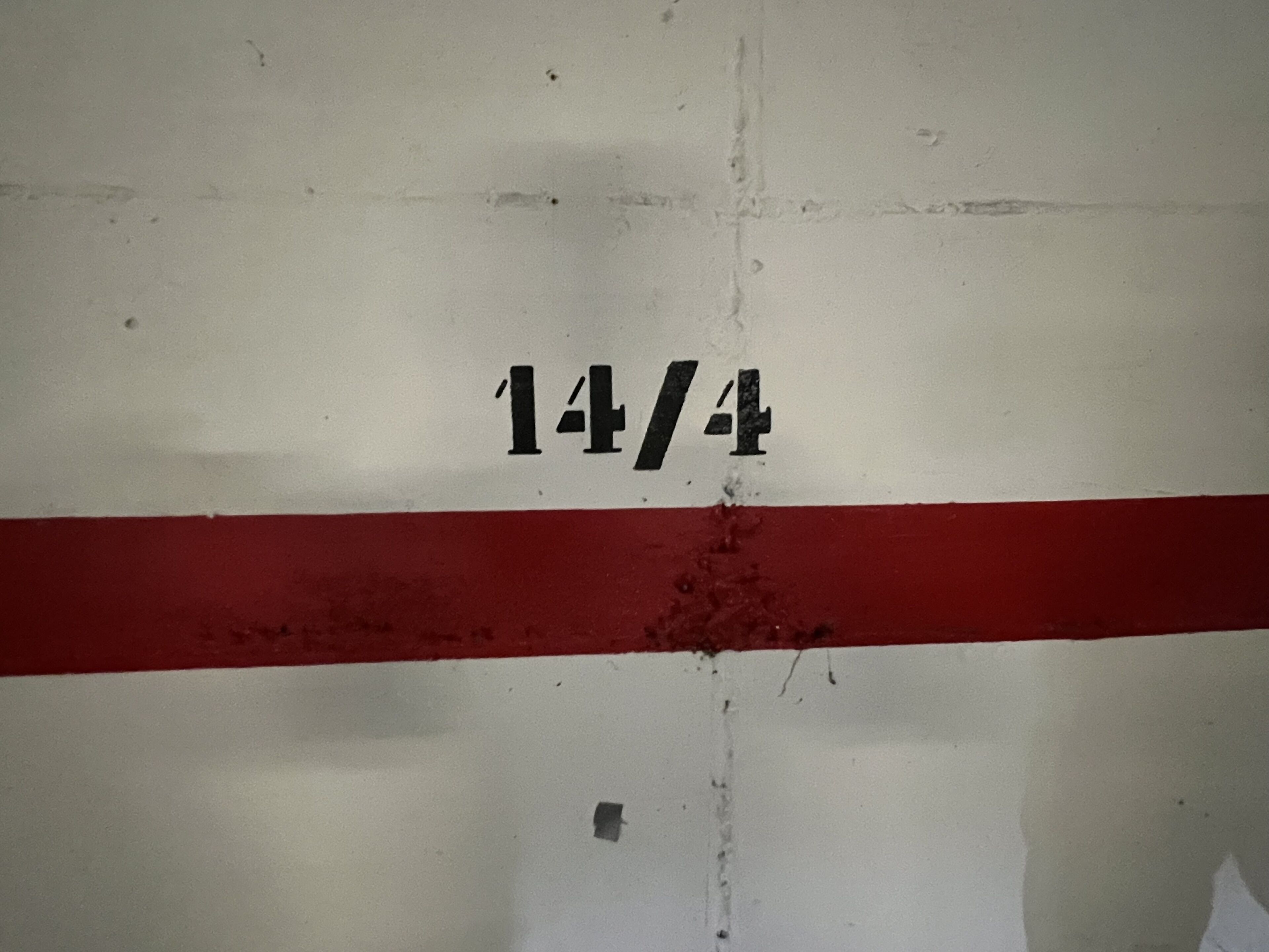 Een muur met daarop de cijfers 14/4 geschilderd.