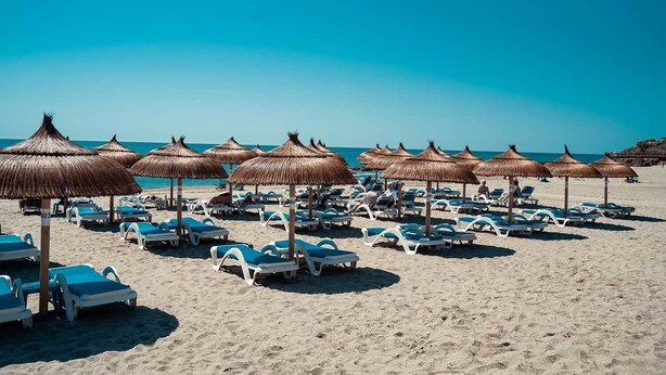 A beach with rows of sun loungers and thatched umbrellas. - Rancho Mirafoles apartment, Sea Views (Mijas)