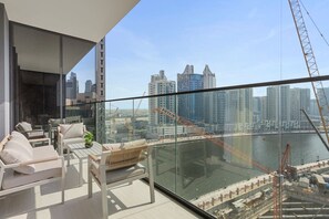 Ein moderner Balkon mit Glasgeländer und Blick auf Stadtbild und Baustelle.