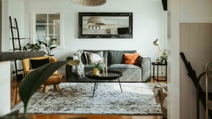 Een woonkamer met een bank, salontafel en een grote spiegel aan de muur.