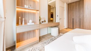 Un dormitorio moderno con una cama grande, estanterías de madera, un espejo y un vestidor.