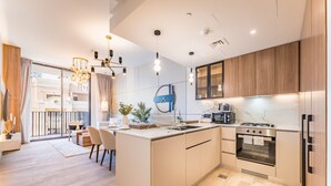 Una cocina moderna con una isla central, electrodomésticos de acero inoxidable y vistas al exterior.