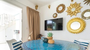 A dining area with a round table, chairs, and decorative wall elements.