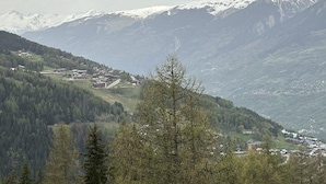 Eine gebirgige Landschaft mit einem Dorf, eingebettet in ein Tal.