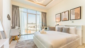 Un dormitorio moderno con una cama grande, un escritorio y vistas a la ciudad.