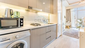 Una cocina moderna con electrodomésticos integrados, lavadora y comedor con vistas.