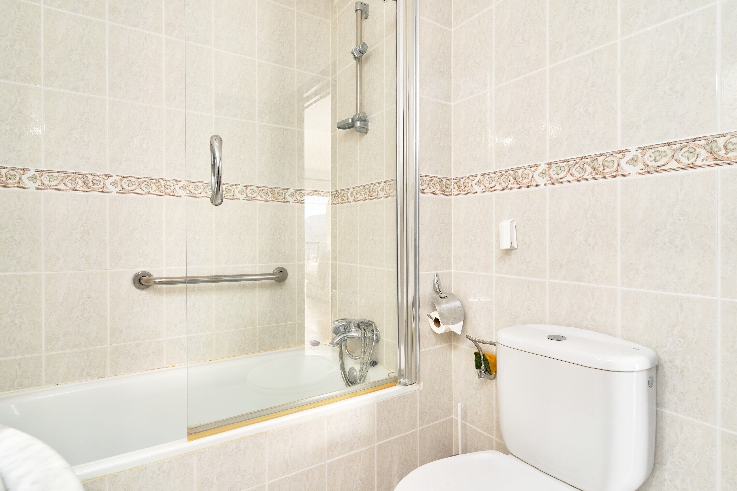 A bathroom with a glass shower enclosure, a white toilet, and a bathtub.