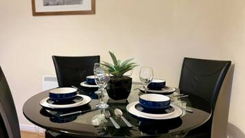 Een eettafel gedekt met blauwe en witte borden, een glas, een lepel en een vork.