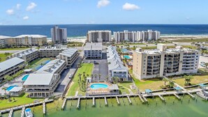 A resort with multiple buildings, a swimming pool, and a marina. - Orange Beach Oasis - Old River Front with 1 minute walk to beach! (Orange Beach)