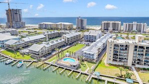 A coastal hotel with multiple buildings, a marina, and a pool area. - Orange Beach Oasis - Old River Front with 1 minute walk to beach! (Orange Beach)