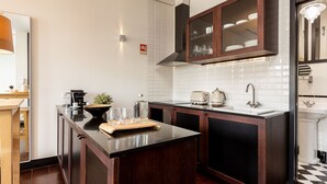 A modern kitchen with dark wooden cabinets, a black countertop, and a white tiled backsplash.