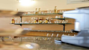 Eine Bar mit Regalen voller Flaschen und Gläsern.