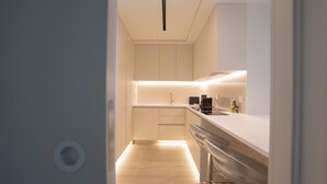 A modern kitchen with white cabinets, a wooden countertop, and a built-in oven. - Cloud9 by LovelyStay | Heaven with Private Pool (Funchal)