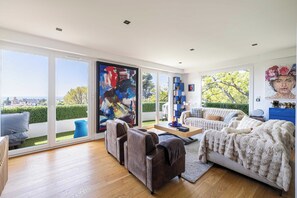 Un salon spacieux avec une grande fenêtre, un ensemble de canapés et une table basse.