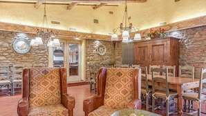 A spacious dining area with stone walls, wooden furniture, and a chandelier. - Villa Vasari - Six Bedroom Villa, Sleeps 12 (Reggello)