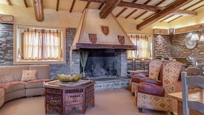 A cozy living room with a stone fireplace, wooden beams, and traditional furnishings. - Villa Vasari - Six Bedroom Villa, Sleeps 12 (Reggello)