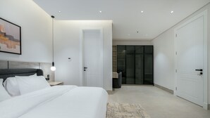 Ein modernes Schlafzimmer mit einem großen Bett, Nachttischen, einem Kleiderschrank und einem Glasfaltschrank.