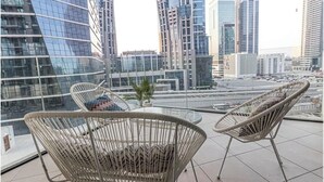 Une chambre d’hôtel moderne située en milieu urbain, dotée de grandes fenêtres offrant une vue sur la ville.