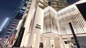 Ein modernes Hotel mit einzigartigem architektonischem Design, das einen markanten Eingang und eine Reihe von Balkonen aufweist.