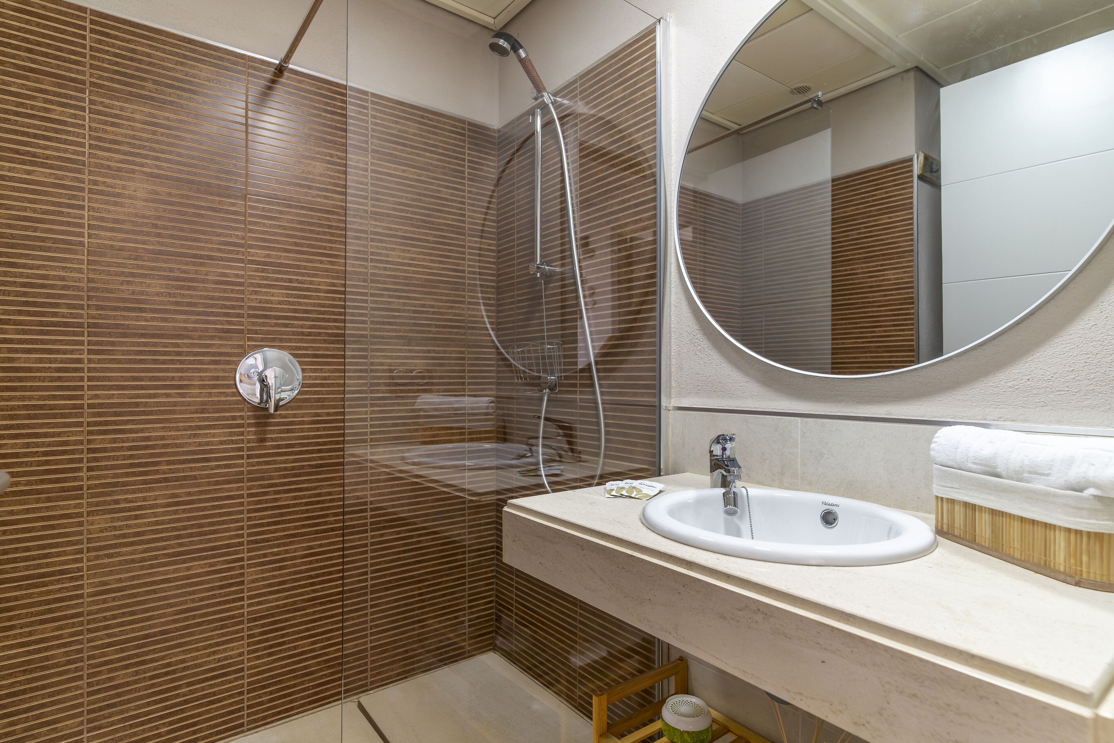 A modern bathroom with a shower, a sink, and a mirror.