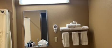 A bathroom with a sink, mirror, towel rack, and toilet.