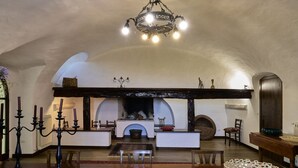 A cozy interior with a fireplace, wooden beams, and a chandelier. - GuestHost - Relax in the natural park/20 minutes from the sea (Sassari)
