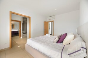 A bedroom with a bed, a wardrobe, and a bathroom visible through an open door.