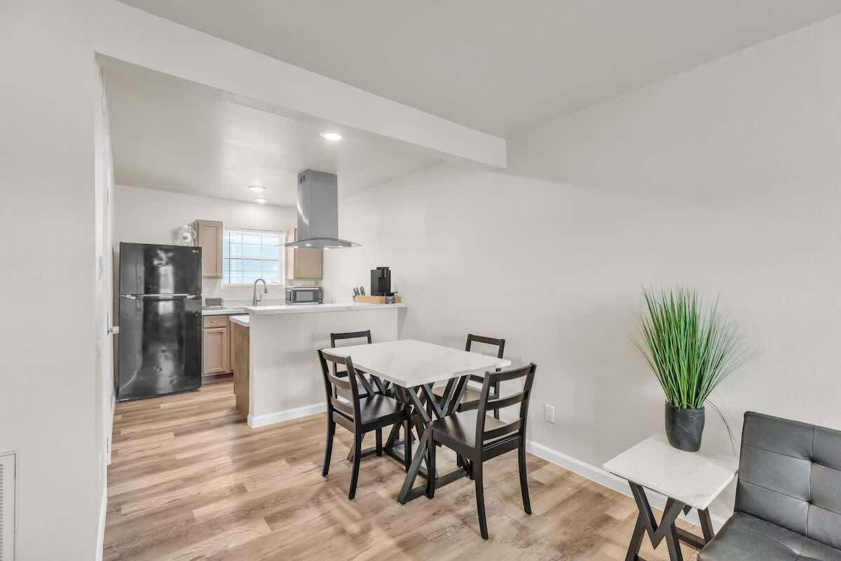 Cocina moderna con comedor, refrigerador y una planta en maceta.