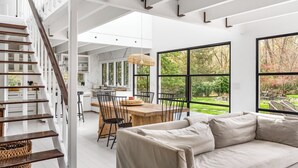 Eine geräumige Küche mit einer großen Kochinsel, ein Essbereich mit Holztisch und Stühlen sowie eine gemütliche Sitzecke mit einer Couch.