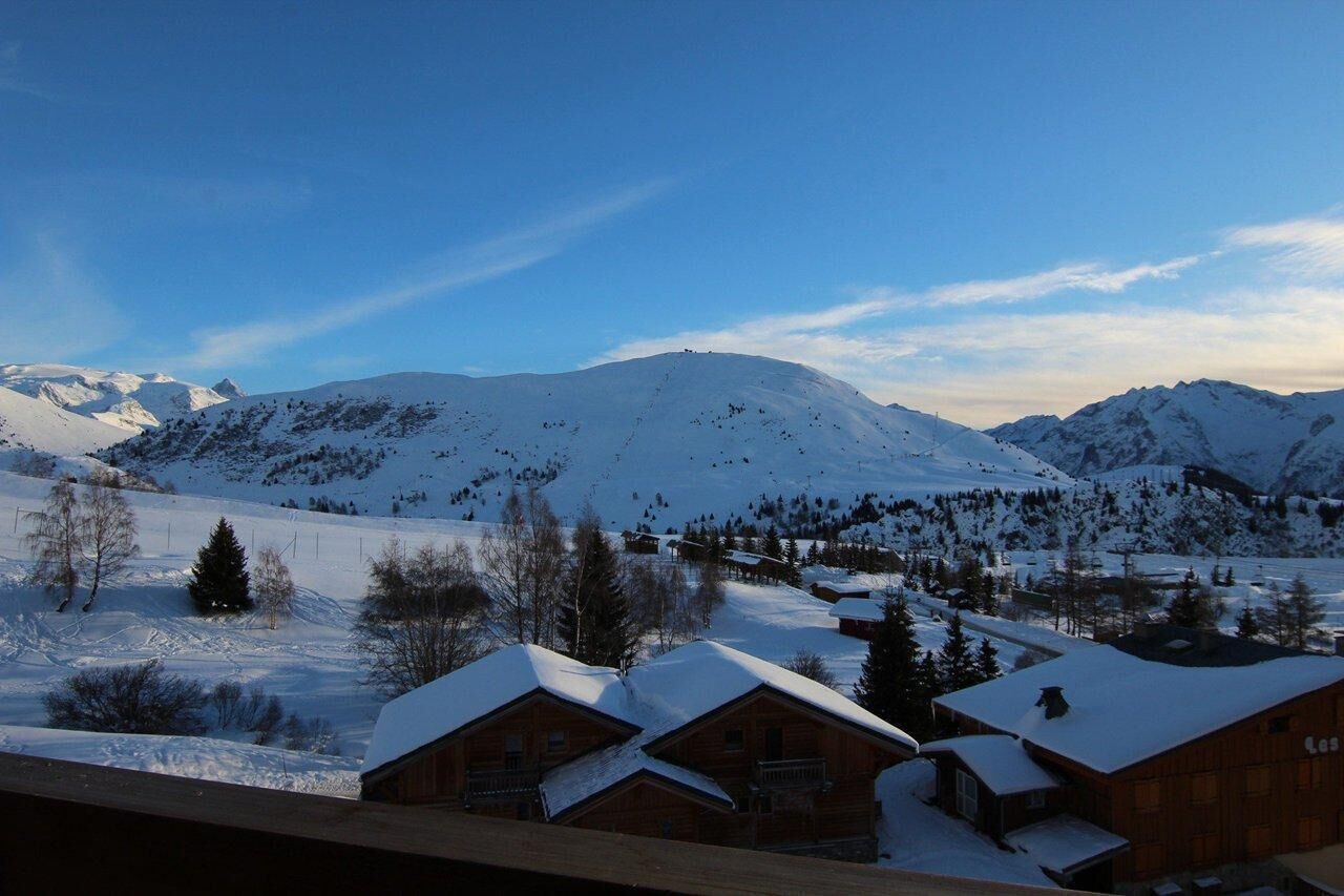 Eine verschneite Berglandschaft mit Holzhütten.