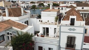 Eine Küstenstadt mit weißen Häusern, einem sichtbaren Balkon und freiem Blick auf das Meer.