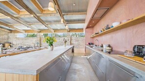 A modern kitchen with a central island, stainless steel appliances, and wooden beams. - South Barns a spacious barn conversion near Cowes. (Cowes)