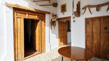 Een kamer met houten deuren, een ronde tafel en een decoratie aan de muur.