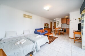 A modern apartment with a bedroom, living area, and kitchen. - Apartment 'Jardins Da Rocha' with Sea View, Wi-Fi and Air Conditioning (Portimão)
