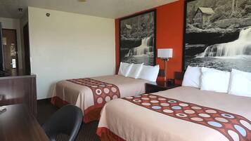 A hotel room with two beds, a desk, a chair, and a large wall-mounted picture of a waterfall.