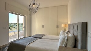 A hotel room with two beds, a balcony, and a view of the outdoors. - Cruzeiro by Check-in Portugal (Quarteira)