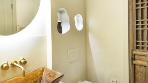 A bathroom with a wooden vanity, a white toilet, and a wooden door. - Solace | Finest Stays (Totnes)