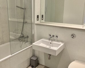 Ein Badezimmer mit Duschkabine, Waschbecken und Toilette.