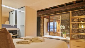 Ett modernt hotellrum med en stor säng, en inbyggd garderob och utsikt genom en glasdörr.