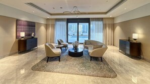 Un moderno vestíbulo de hotel con un área de descanso, una mesa de centro y vistas de la ciudad a través de amplias ventanas.