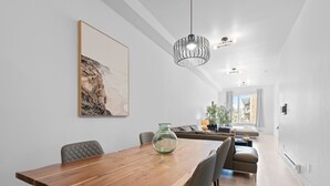 Un comedor moderno con una mesa de madera, sillas y una lámpara colgante.