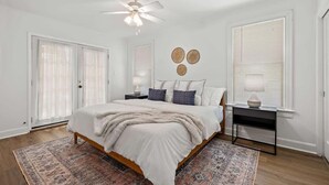 A bedroom with a bed, bedside tables, a ceiling fan, and a patterned rug. - Villa in Zilker - Peaceful Stylish Home with Yard (Austin)