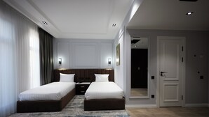 A modern hotel room with two beds, a large window with curtains, a wooden floor, and a door leading to another room. - Noble Samarkand (Samarkand)