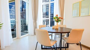 Un espace repas moderne avec une table ronde, quatre chaises et un vase de fleurs.
