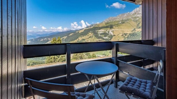 A balcony with a table and chairs, offering a view of a mountainous landscape. - 40m from ski slopes, 5th floor, view valley, balcony, tv, 50m², Méribel-Mottaret (Méribel - Les Allues)