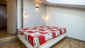 A bedroom with a bed, wooden flooring, a white wall, and a skylight. - 40m from ski slopes, 5th floor, view valley, balcony, tv, 50m², Méribel-Mottaret (Méribel - Les Allues)